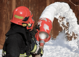 A Firefighter Spraying Snow On A Pole