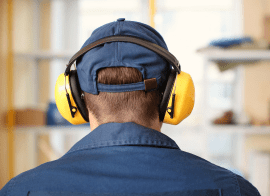 A Man Wearing Ear Muffs And Blue Shirt