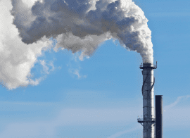A Smokestack With Smoke Coming Out Of It