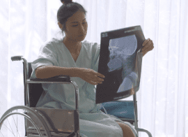 Women Examining Her Traumatic Brain Injury X-Ray In Wheelchair