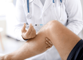 Doctor Providing A Steriod Injection Into A Veteran'S Knee To Help With Pain Management