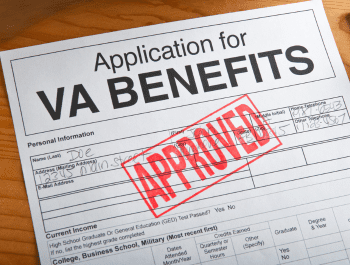Image Of A Previously Denied Application For Va Benefits On A Table With A Large Red Approved Stamp